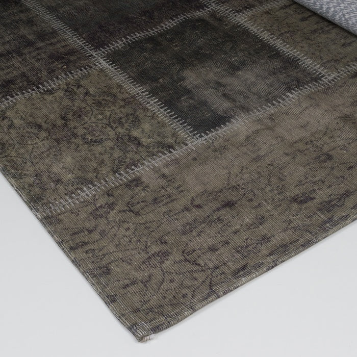Karpet hoekdetail met grijs-olijf vintage patchwork en gedessineerde textuur