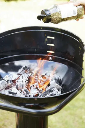 Zwarte houtskoolbarbecue met brandende houtskool in de vuurkom