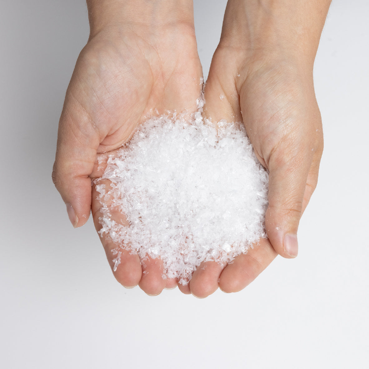 Fijne witte sneeuwvlokken in twee handen