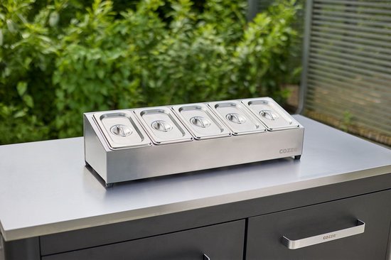 Toppingstation met 5 roestvrijstalen bakjes en deksels, op werkblad met zilveren behuizing