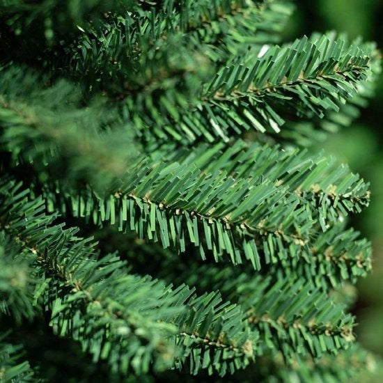 Kunstkerstboomtak met groene naalden en twinkelende lichtjes, detail