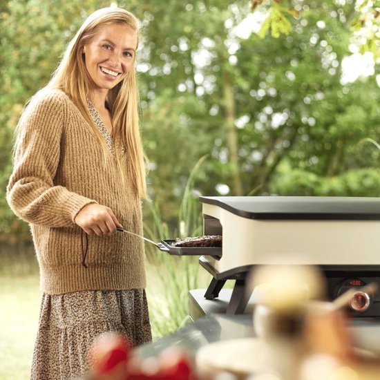 Elektrische pizzaoven met pizza in de oven, persoon plaatst het gerecht