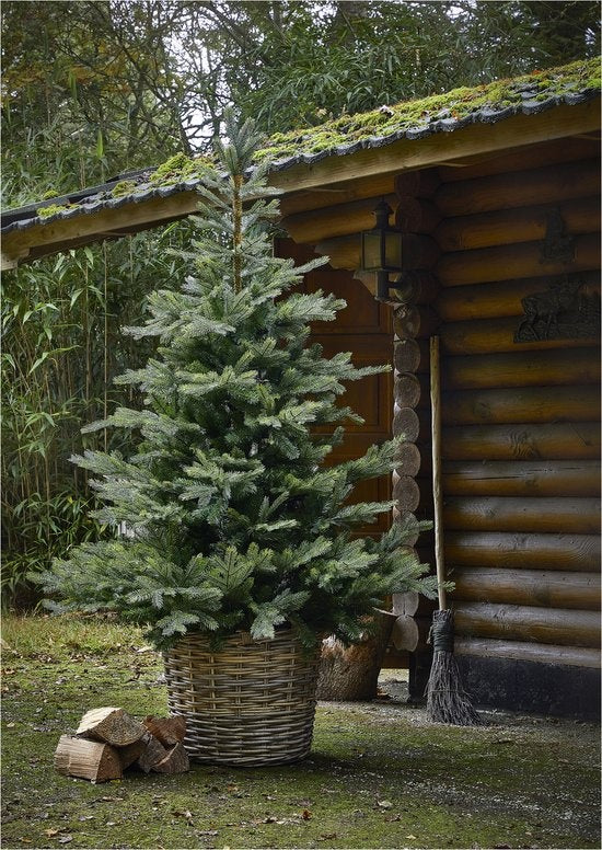 Kunstkerstboom in geweven mand, groene naalden en takken