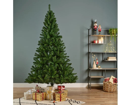 Groene kunstkerstboom op de vloer met cadeaus eromheen