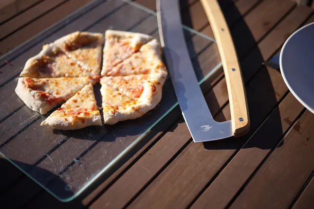 Pizza snijblad met houten handgreep op gegrilde pizza