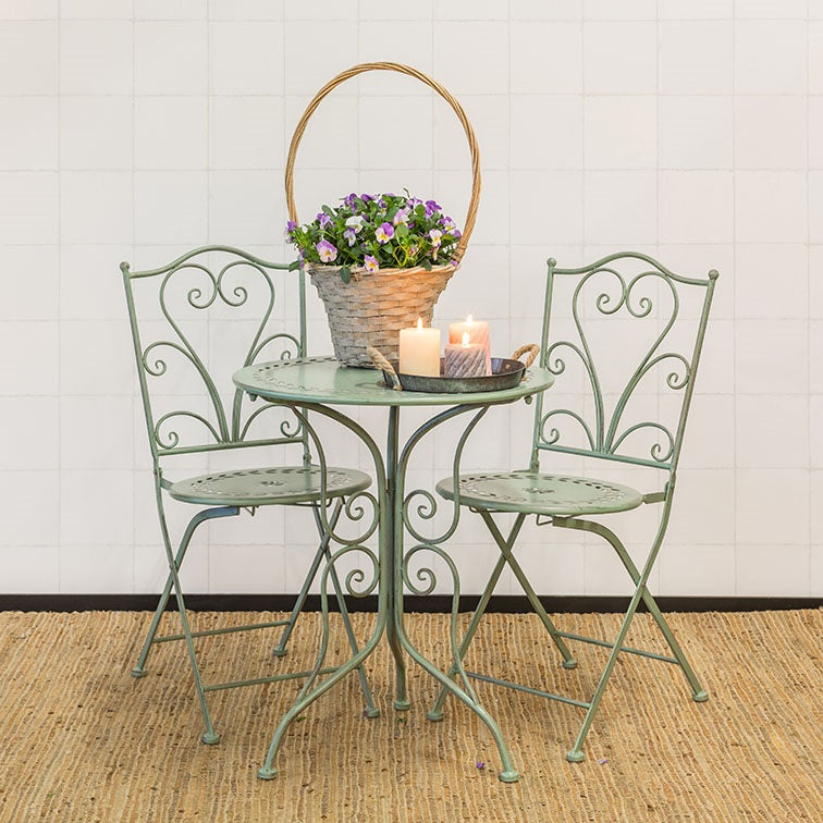 Groene bistroset met rond tafeltje en twee metalen stoelen met sierkrullen