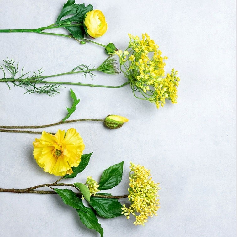 Decoratief bloemstuk met gele bloemen en knoppen, groene stelen en bladeren