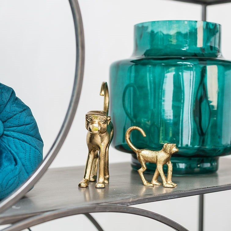 Twee kleine gouden kattenfiguurtjes met staarten omhoog, naast elkaar.