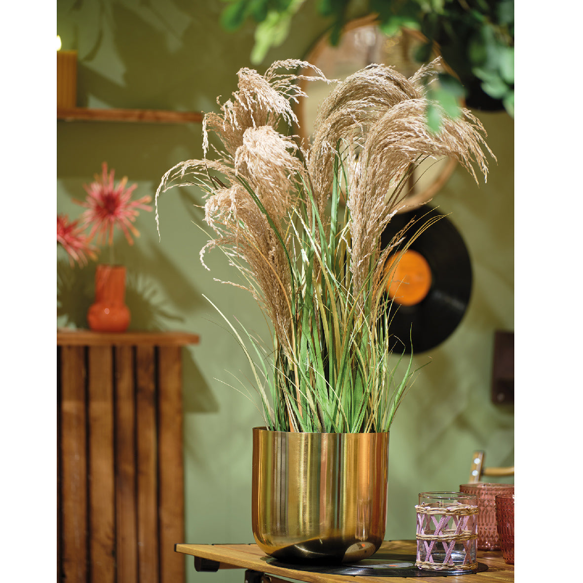 Siergras in gouden plastic pot met volle groene en beige aren