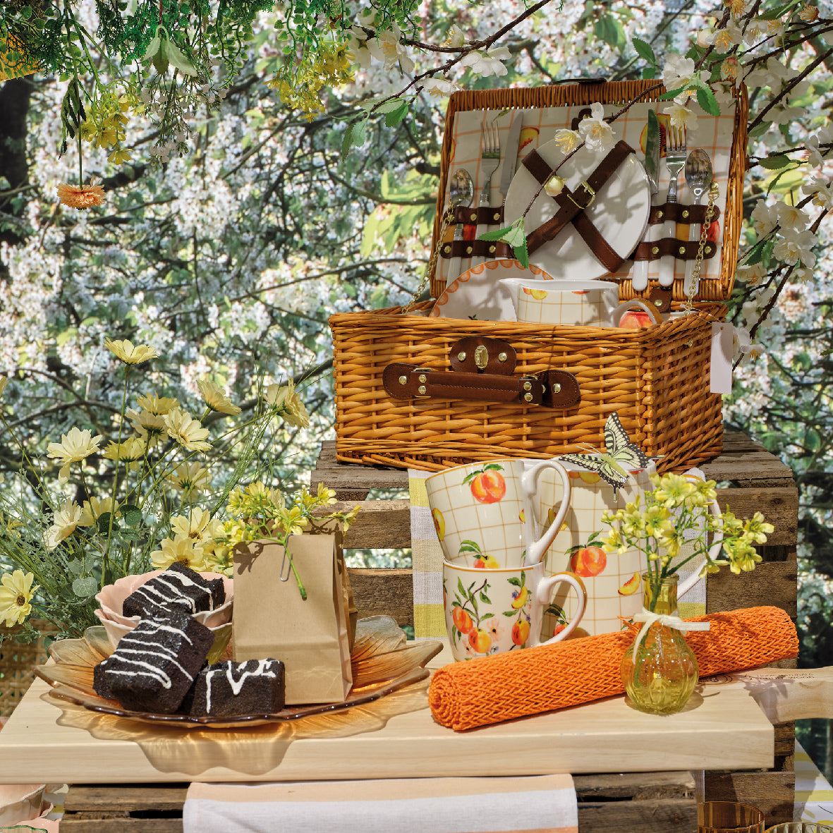 Rieten picknickmand met open deksel op tafel, servies en accessoires voor picknick