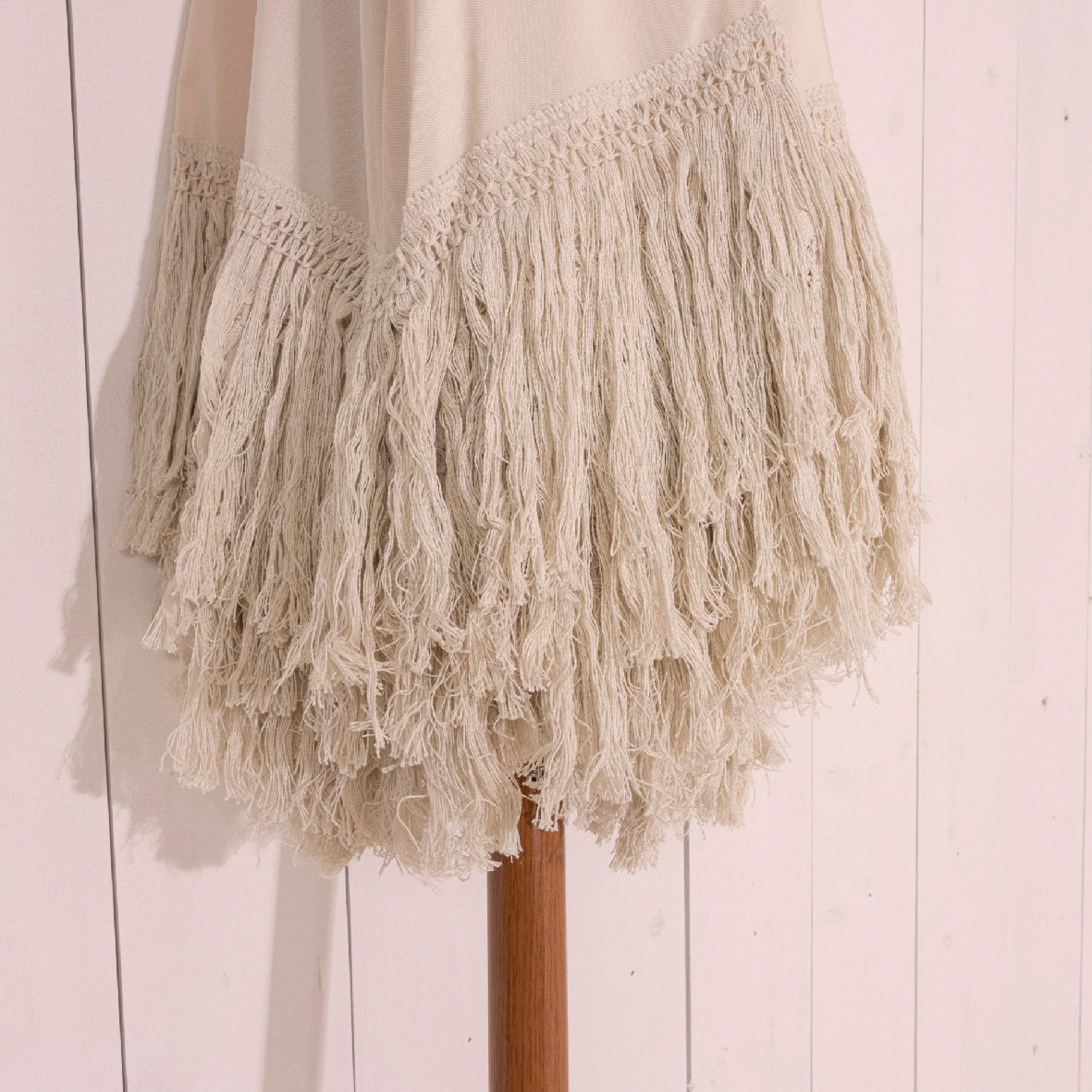 Buitenparasol franjerand van crème polyesterdoek, kwastjes detail