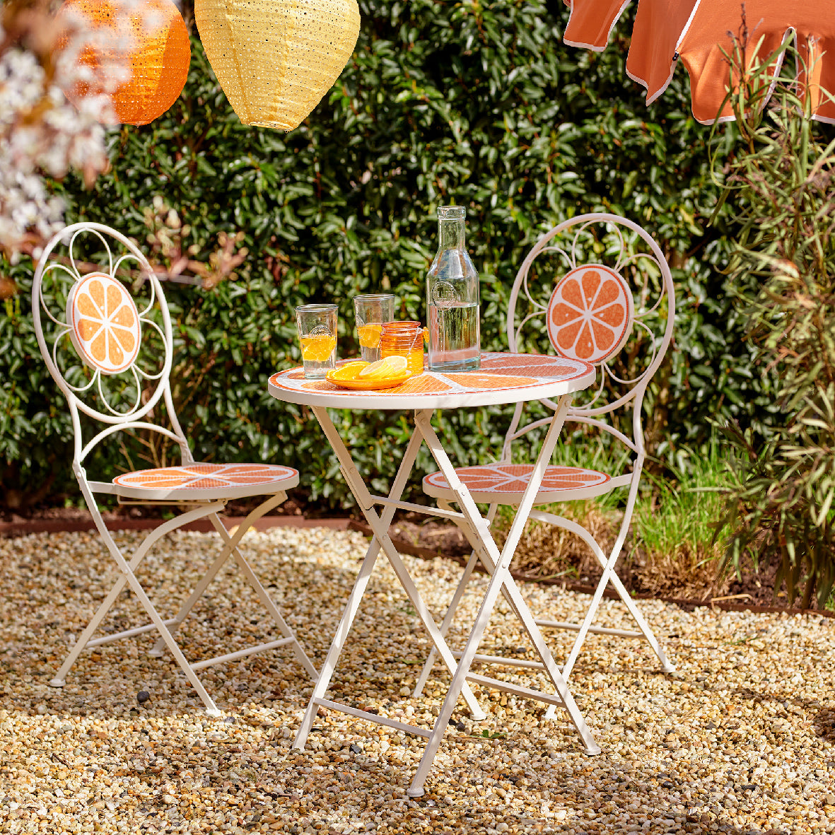 Buiten ijzeren set met ronde tafel en stoelen, oranje bloemmozaïek op blad
