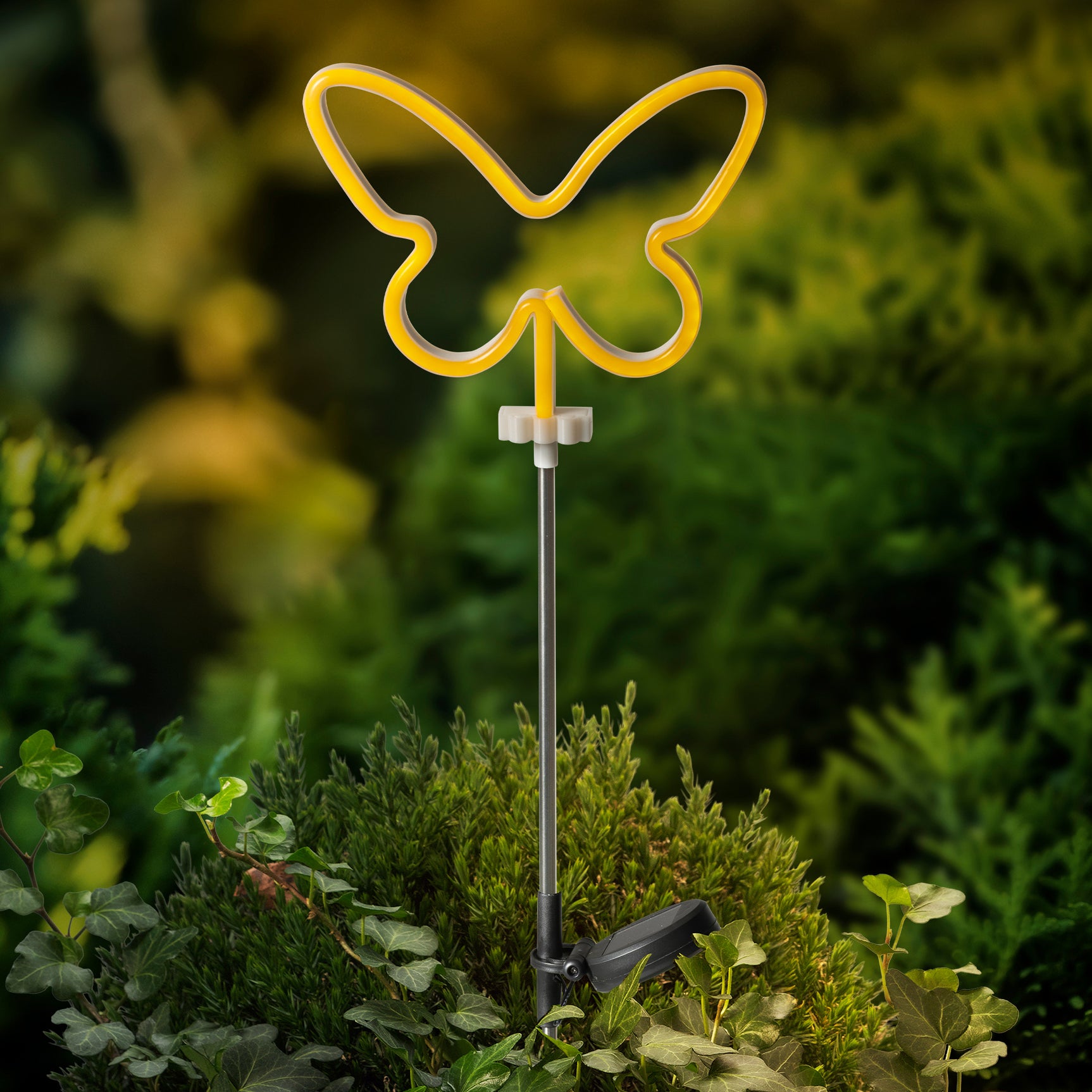 Vlinder zonne-staaklamp met gele LED-omtrek op lange metalen stang, ingeplant in tuin