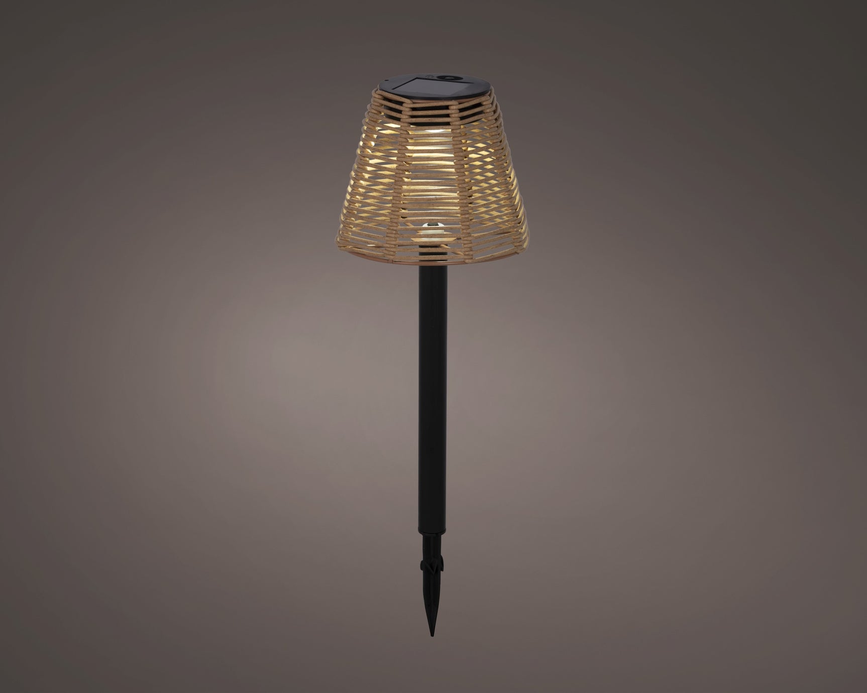 Solar steeklamp met rieten kap en zwarte paal, zonnecelmodule op de bovenkant.
