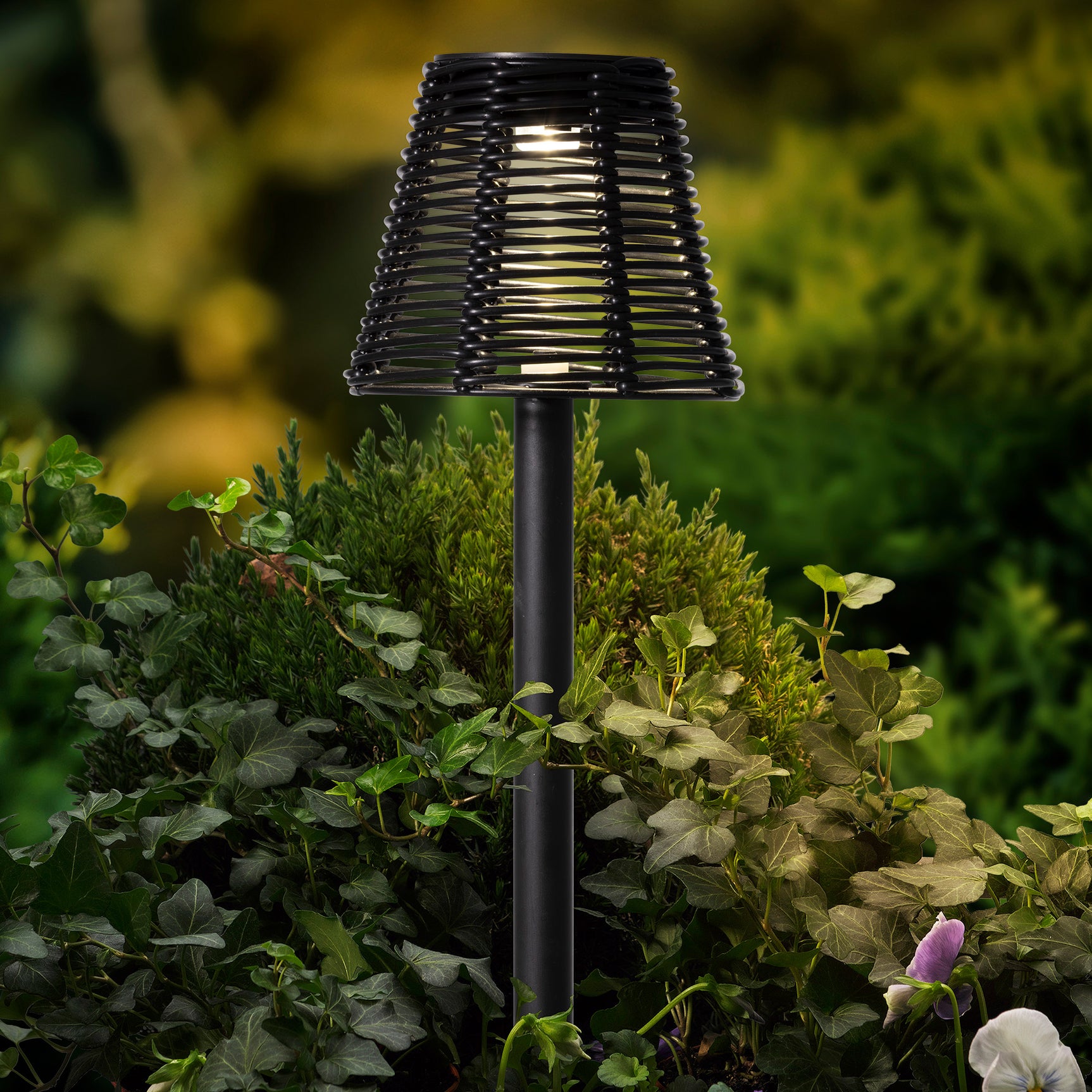 Zwarte zonne-tuinlamp met rieten lantaarnkap en grondpin