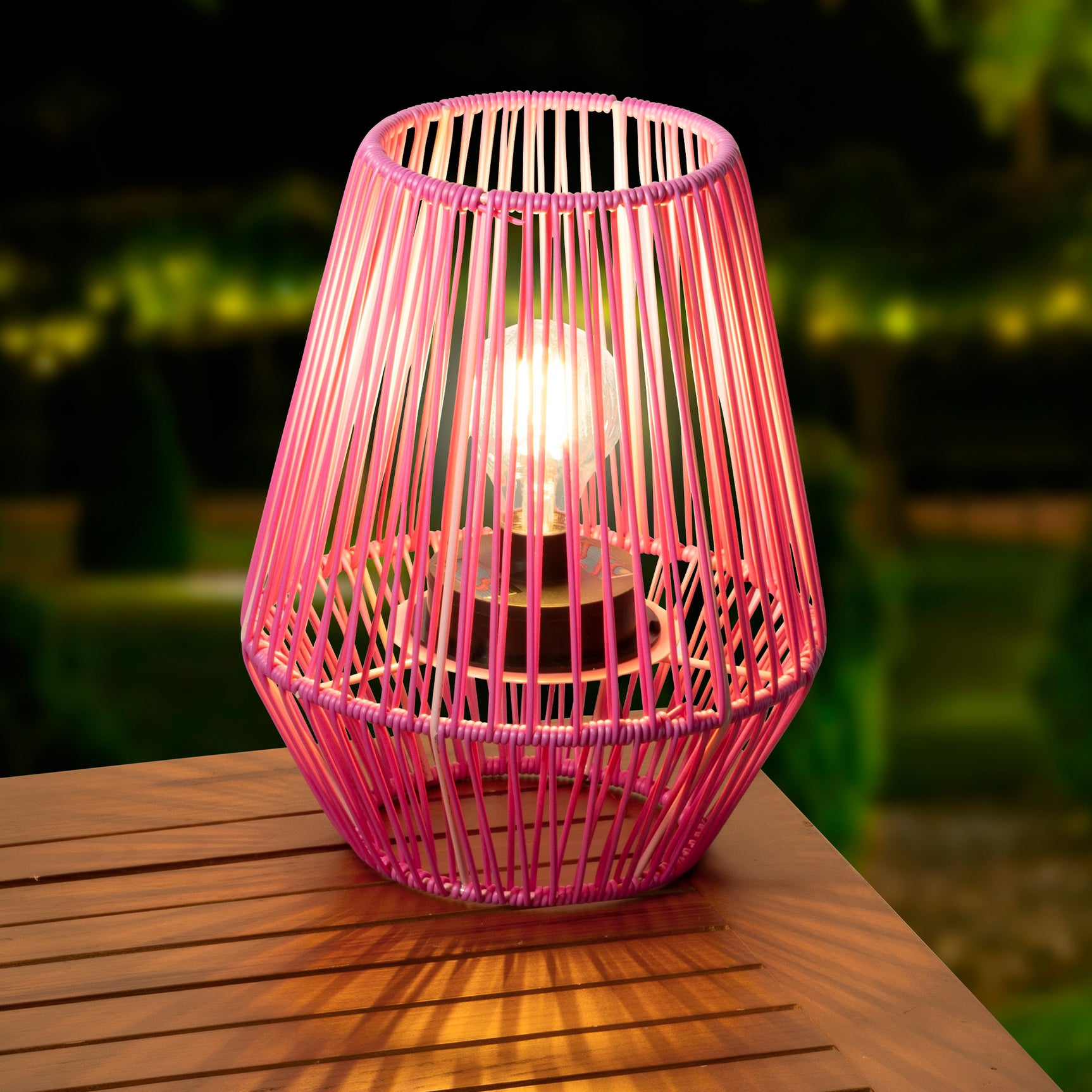 Zonne-lantaarn rotan mand, roze draad, brandend lichtpunt binnenin