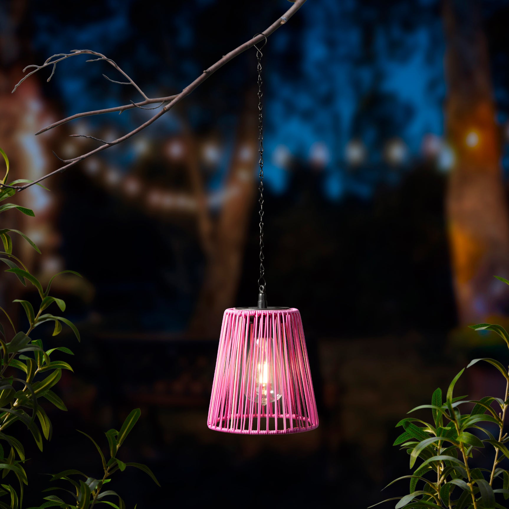 Roze hanglamp met gevlochten rieten kap, verlicht aan een ketting