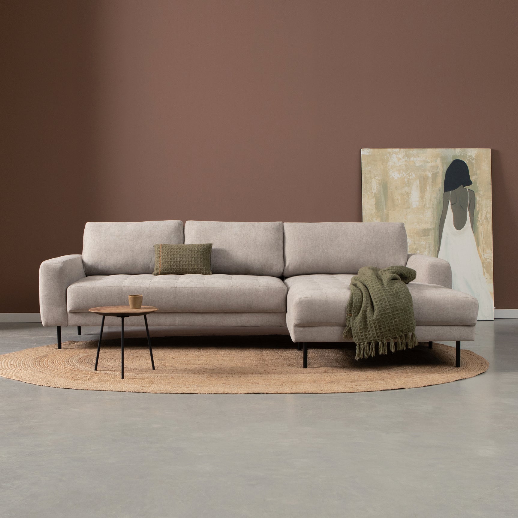 Bank met chaise longue rechts, lichtgrijs gestoffeerd, met kussens en groene plaid