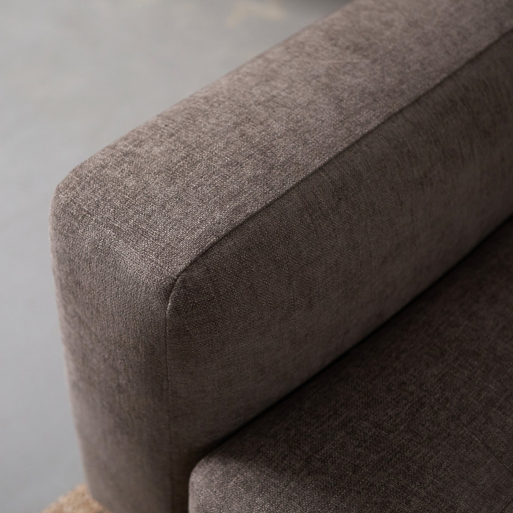Zijkant van grijze bank met chaise longue rechts, dikke armleuning