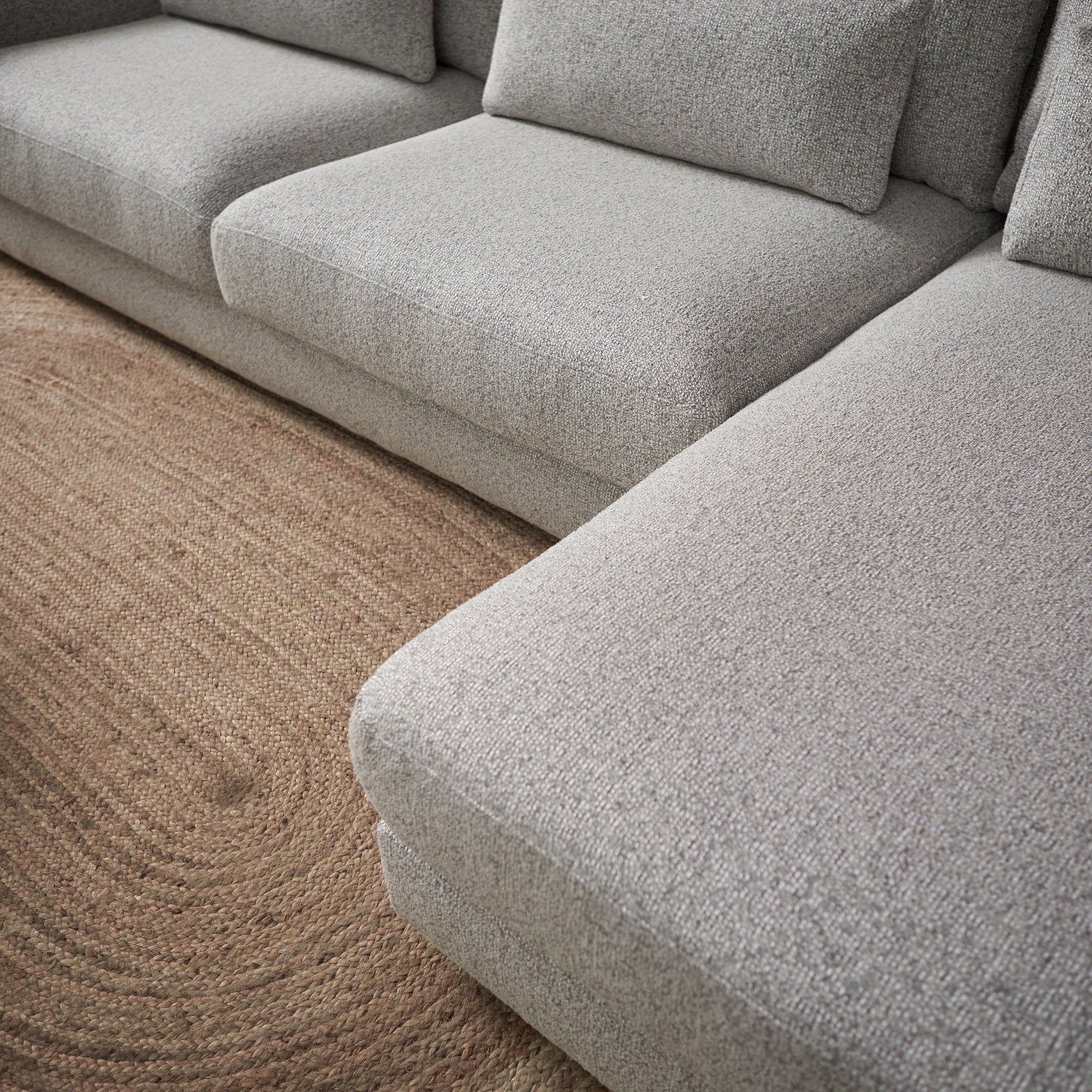 Lichtgrijze chaise lounge met diepe zit, lage armleuning en kussenpartij