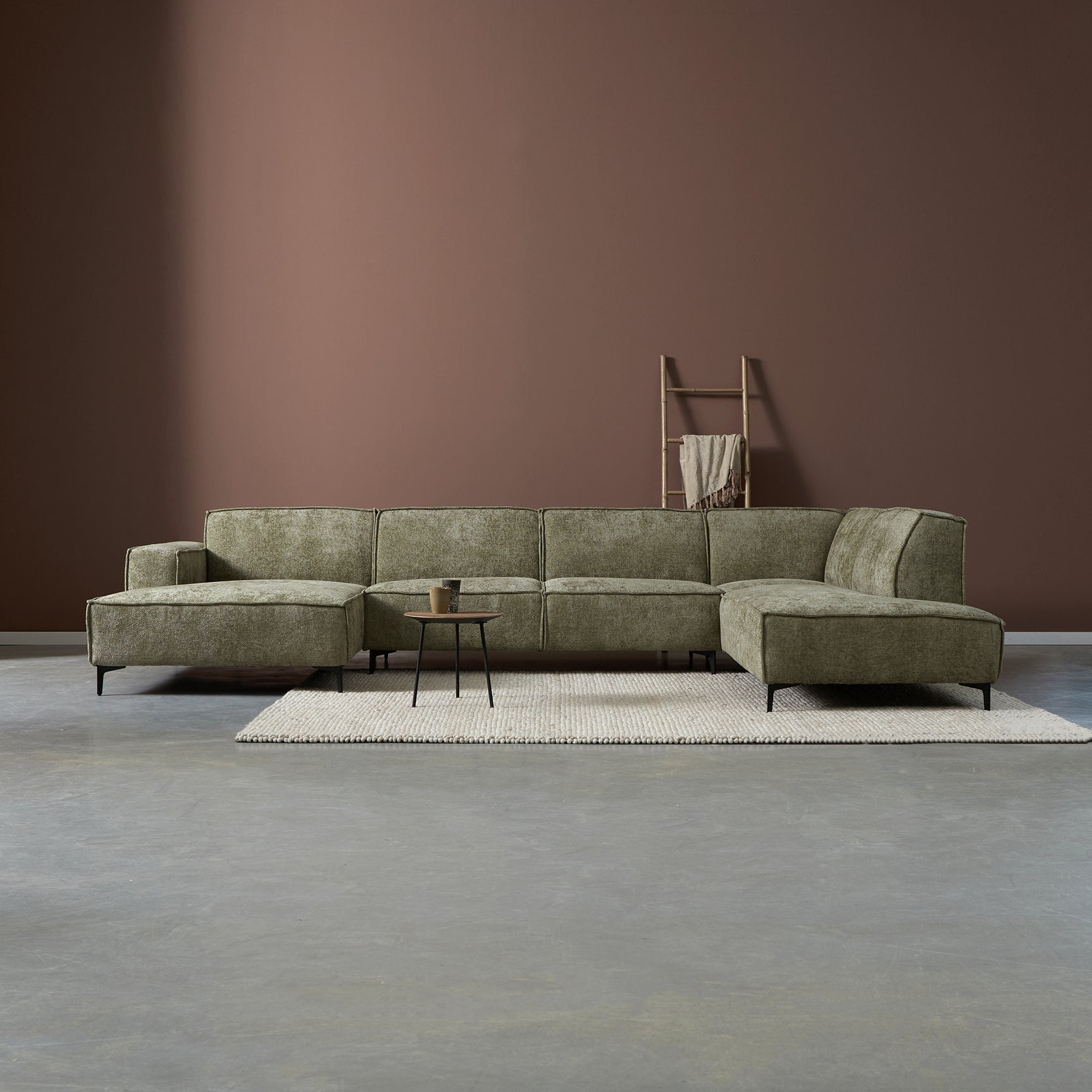 Hoekbank met chaise in groene stoffen bekleding en lage metalen poten