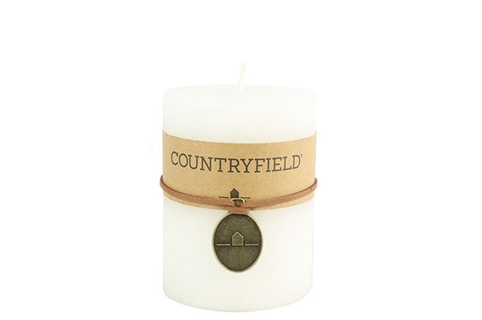 Witte cilindrische kaars met COUNTRYFIELD-etiket en bruine band
