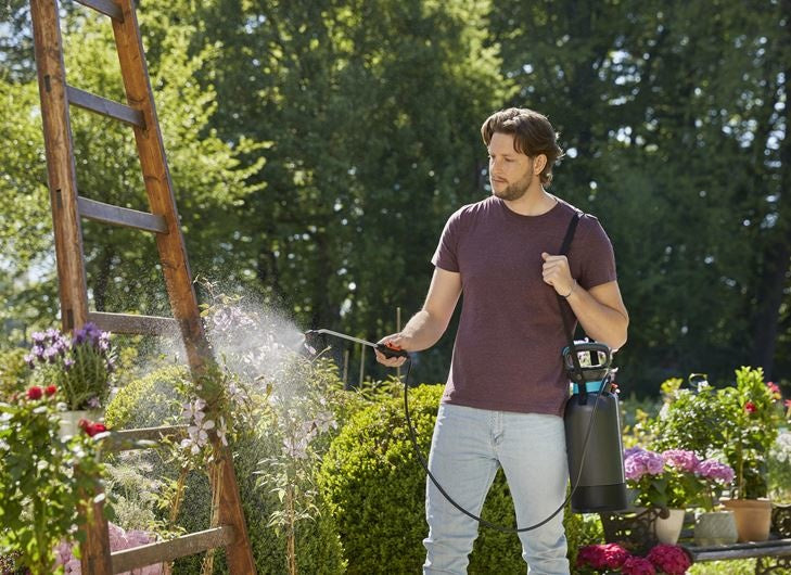 Gardena drukspuit 5 l met spuitmond in gebruik, zwarte tank met turquoise rand