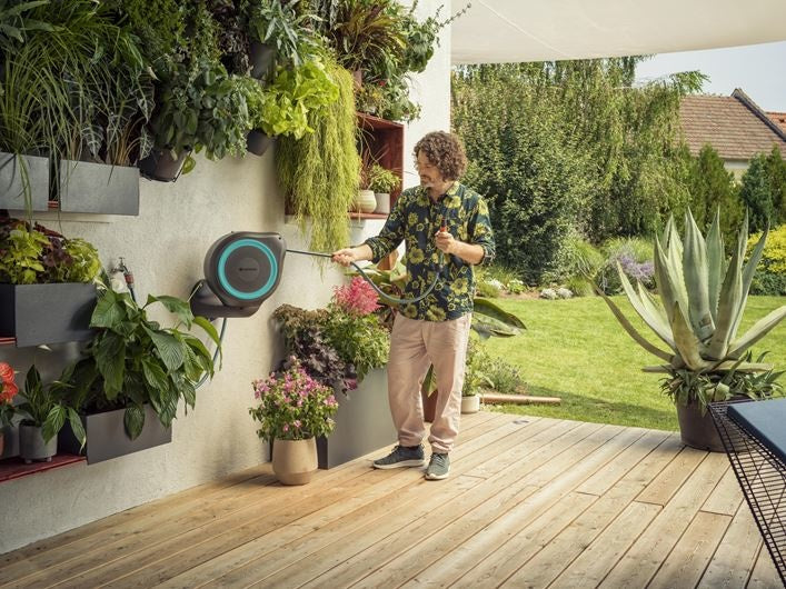 Gardena wandslangenbox aan gevel met aangesloten tuinslang en metalen steun
