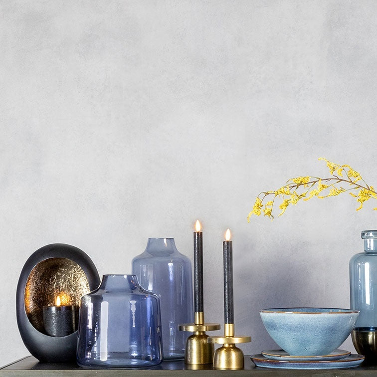 Blauwe glazen flessen op tafel, met kandelaars