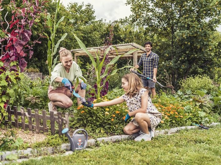 Tuinhandschoenen turquoise en zwart, gedragen tijdens tuinieren door volwassene