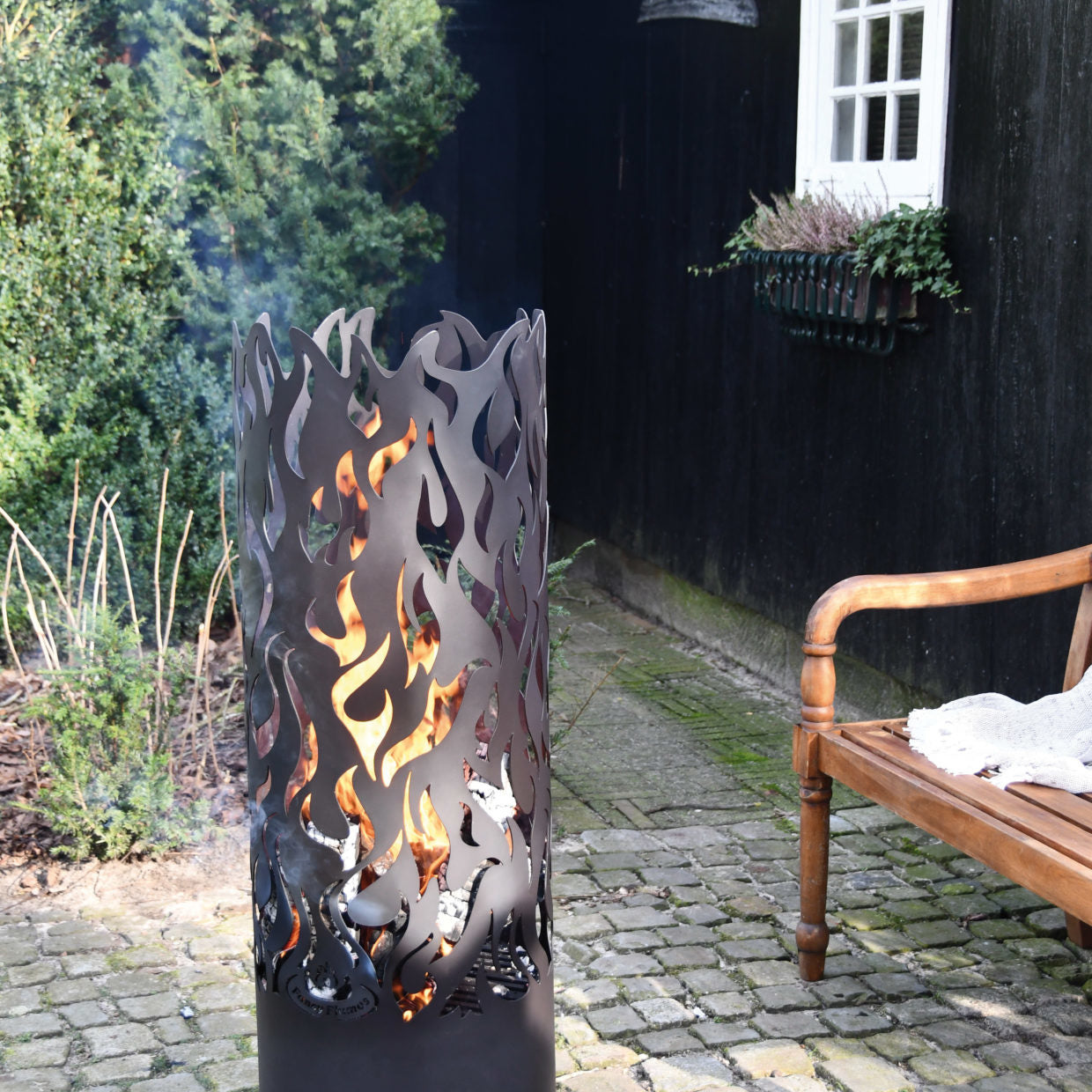 Vuurton Esschert design met vlammenmotief, met brandende vlammen in zwarte cilinder