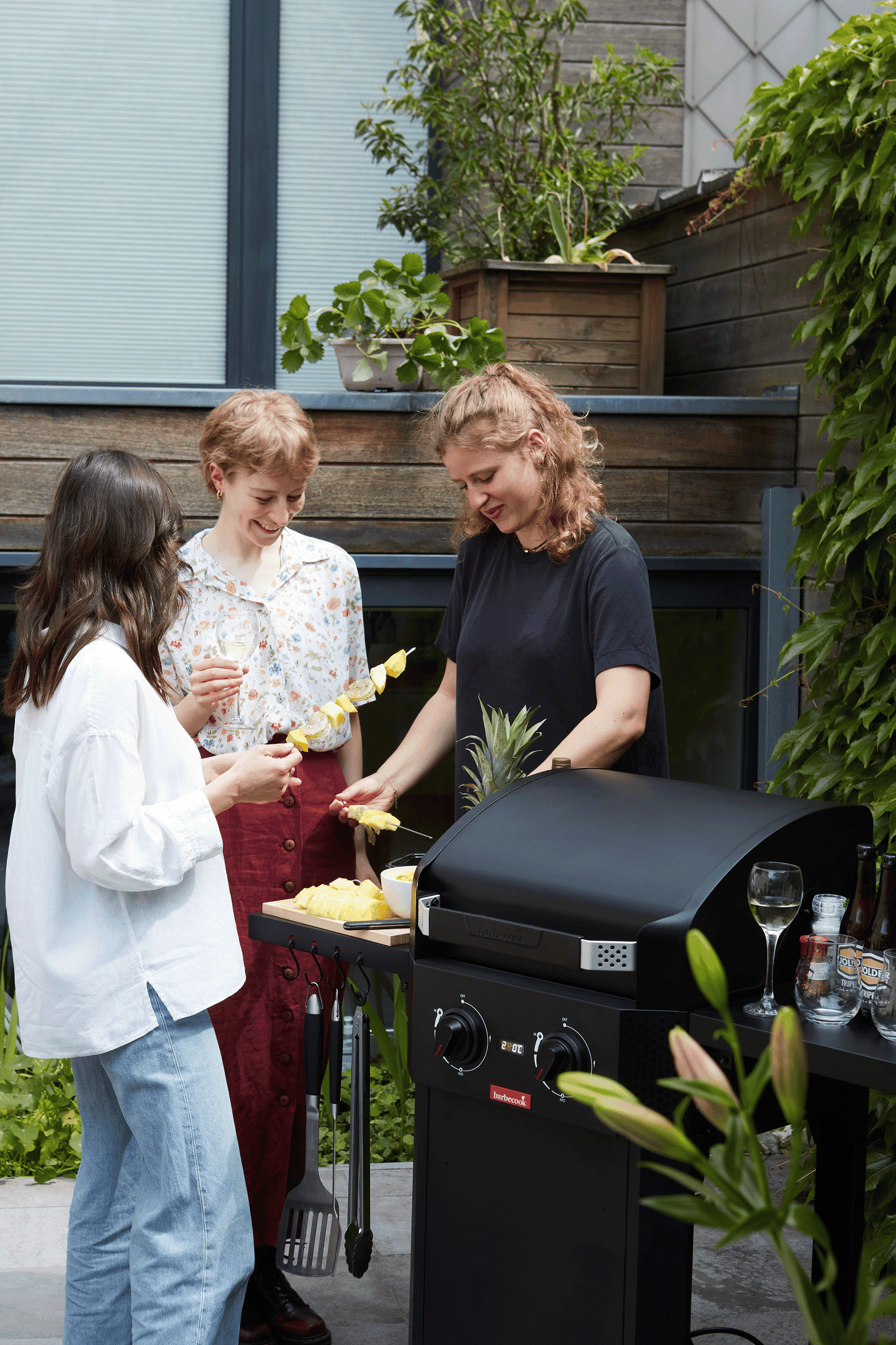 Zwarte elektrische barbecue met open deksel en gegrilde etenswaren op het rooster