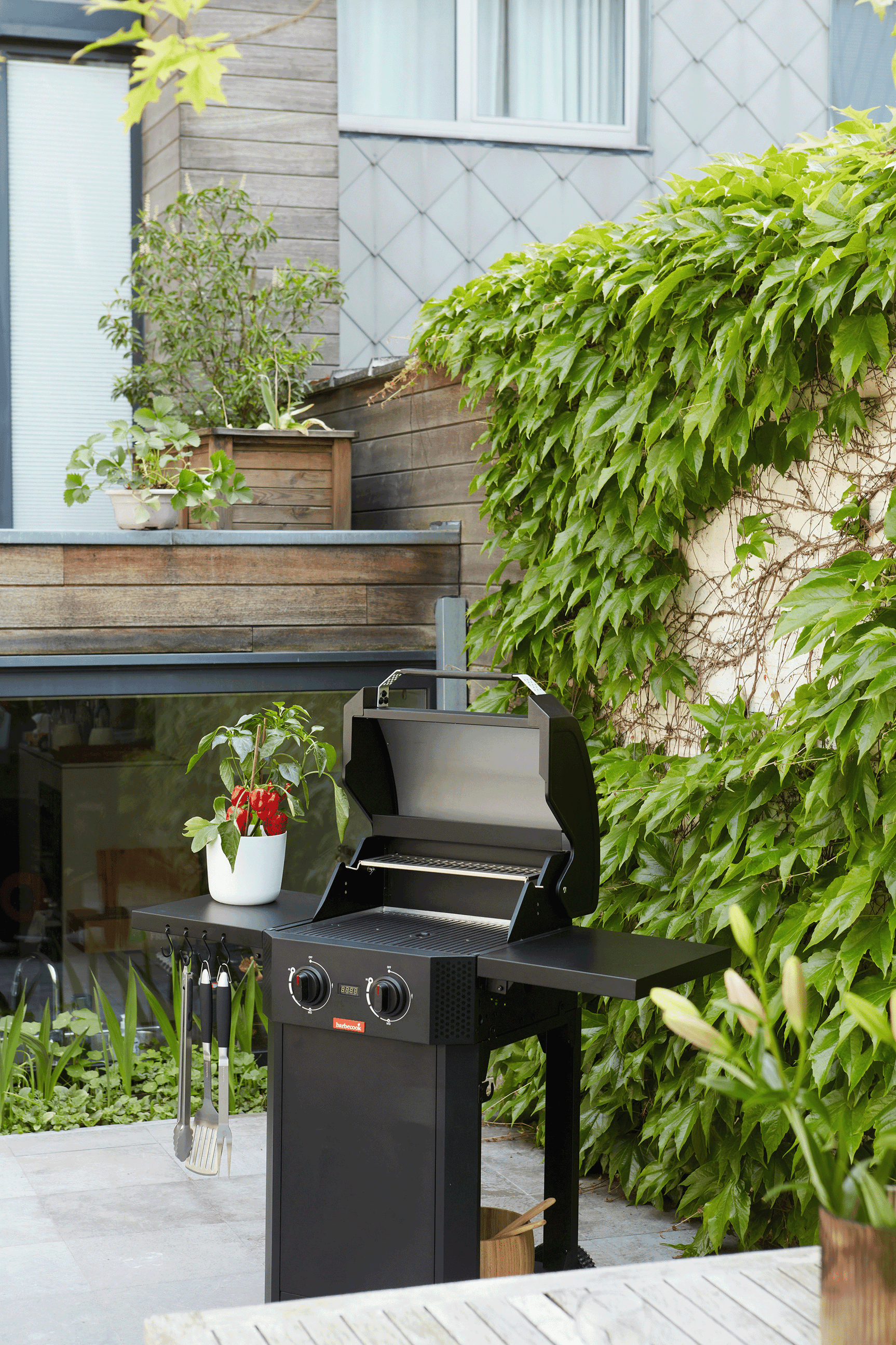 Zwarte elektrische barbecue met open deksel en twee regelknoppen