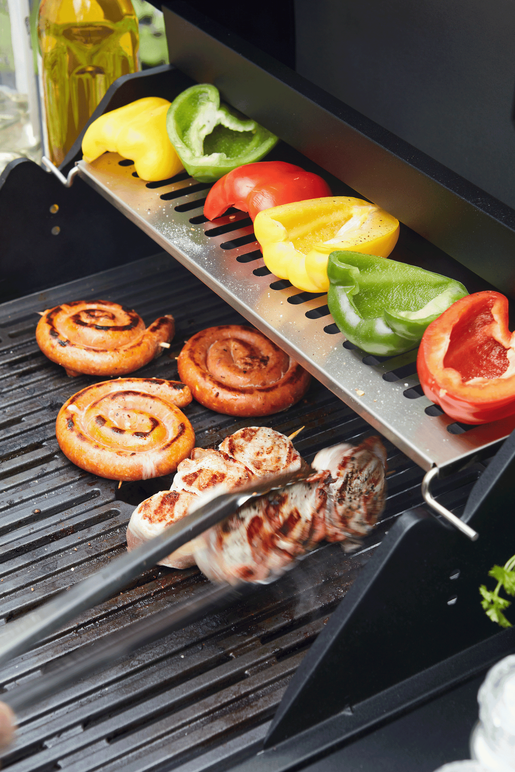Elektrische barbecue met gegrilde groenten en worstjes op het grillrooster