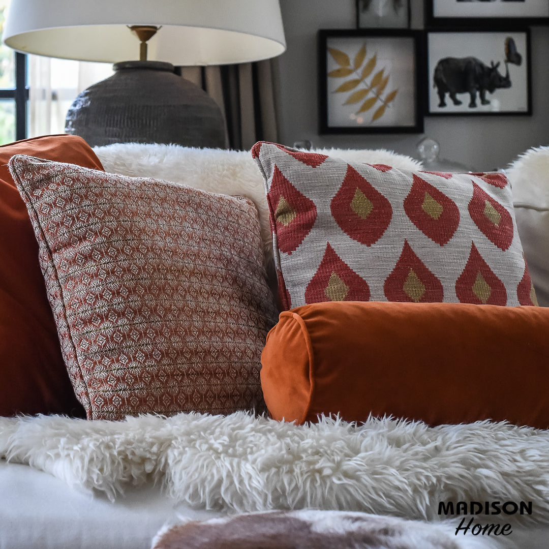 Sierkussen 60x30 cm met rode/oranje druppels en groene accenten op crème
