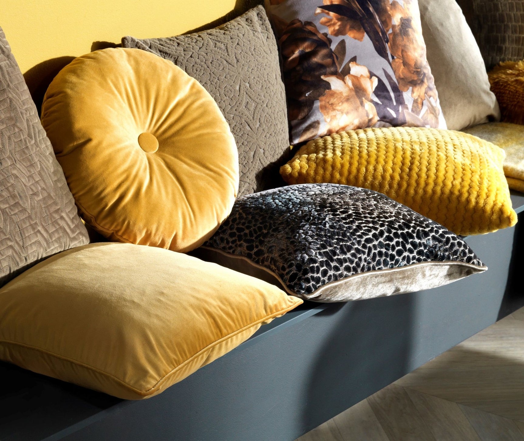 Sierkussen Olly 40 cm Golden Glow, rond geel fluwelen kussen met knoop op bank