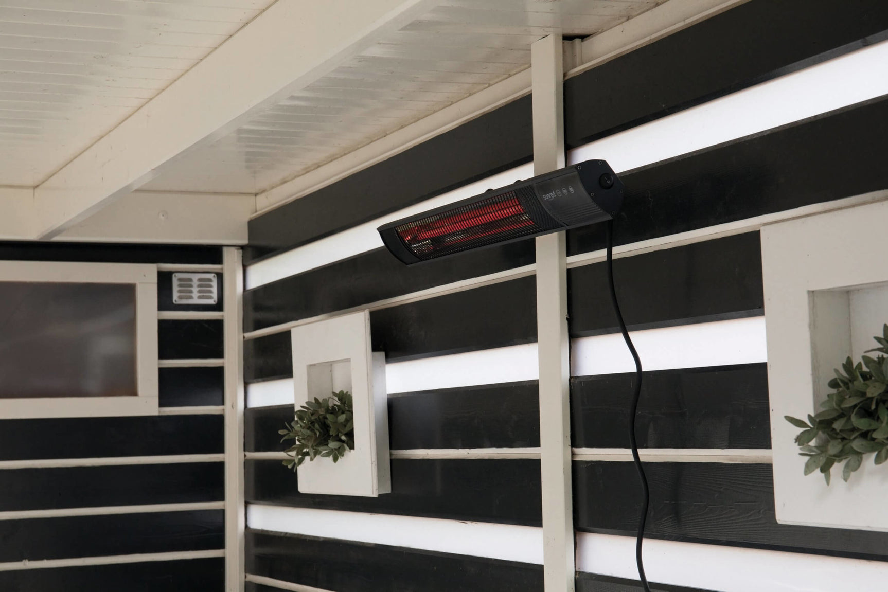 Sunred wandverwarming aan gevel onder overkapping met rode gloed