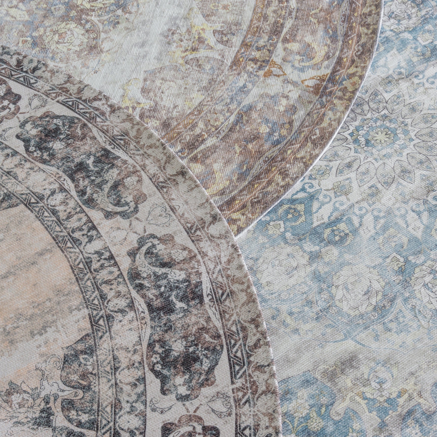 Detail van rond vloerkleed met blauwpastel en beige patronen, donkergrijze rand