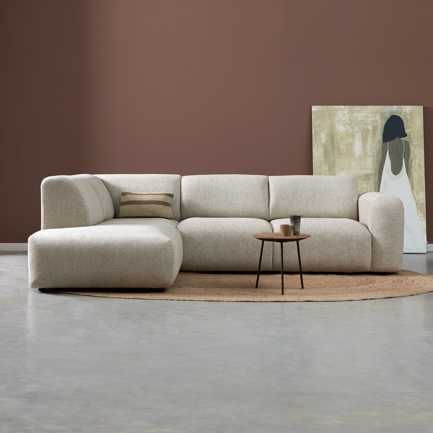 Lichtbeige stoffen hoekbank met links ottoman en brede armleuningen