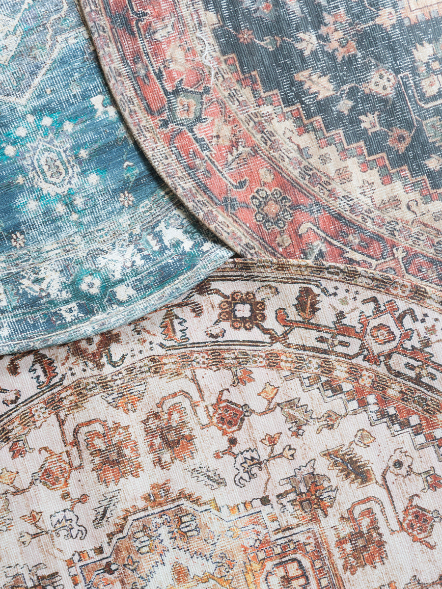 Rond vloerkleed, close-up: wit/beige met bruin ornamenten en blauwgroene decorrand