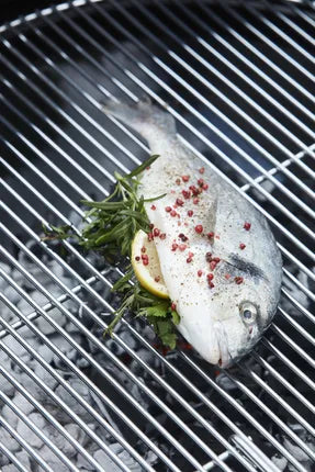Visfilet op het grillrooster van een zwarte houtskoolbarbecue