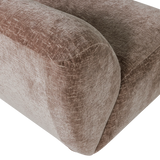Close-up van craquelé velvet fauteuilbekleding in lichtbruin, afgeronde hoek en armzijde.