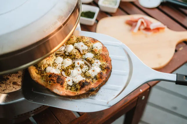 RVS pizzaspatel met zwarte steel, gebruikt om pizza op te scheppen