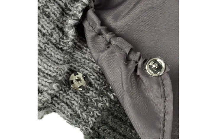 Grijze trui met knoop- en inzetdetail bij de zijkant en ribsteek