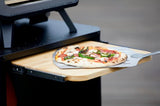 Pizza op pizzaschep en bakplaat van een grill