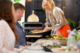 Barbecuegrill met pizza op houten plank