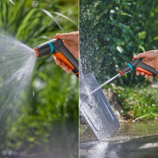 Spuitpistool met oranje trekker spuit een waterstraal op een tuinoppervlak