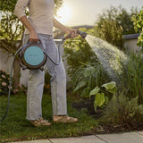 Gardena slangenhaspel met opgerolde slang, klaar om te sproeien in de tuin