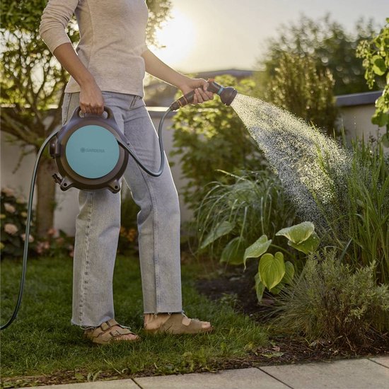 Gardena slangenhaspel met opgerolde slang, klaar om te sproeien in de tuin