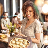 RVS pizzaschep met gaatjes, gebruikt om pizza op te tillen